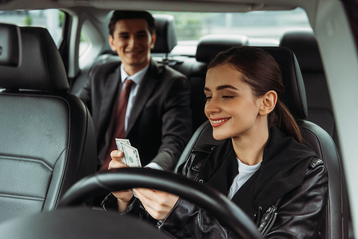 smiling-taxi-driver-holding-cash-with-businessman-2023-05-20-00-47-48-utc.jpg